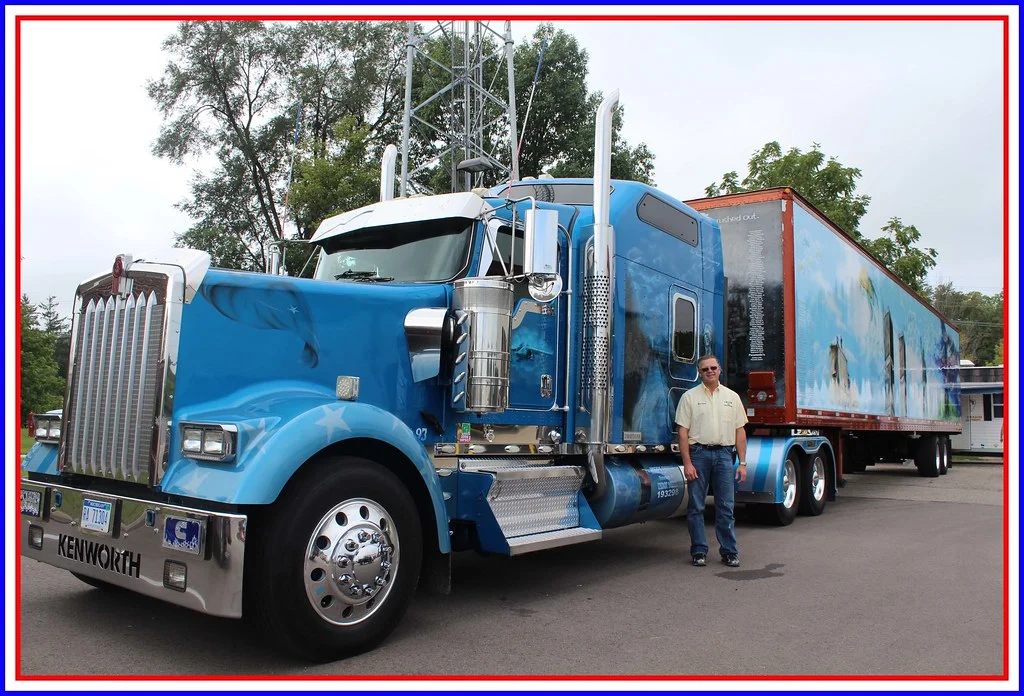 Conducteur routier debout devant son camion poids lourd sur un parking, logistique transport